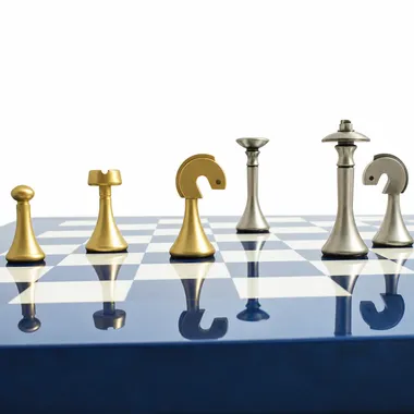 Goud- en zilverkleurige messing stukken op een rij op het blauwe schaakbord