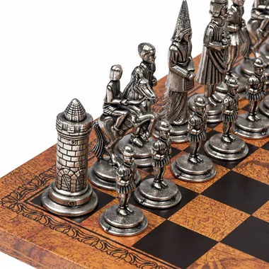 Close-up van de zilveren Camelot-stukken, paarden en toren op het kunstleren schaakbord