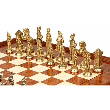 Gouden Napoleon-schaakstukken opgesteld op het essenhouten schaakbord