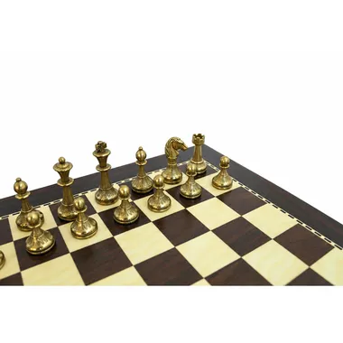 Gouden stukken van het kleine metalen schaakspel opgesteld op het bord