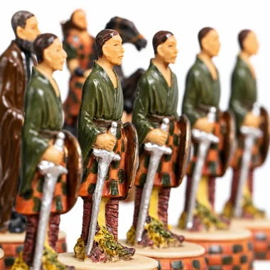 Schaakstukken op een rij met Schotse strijders in kilt gewapend met zwaarden