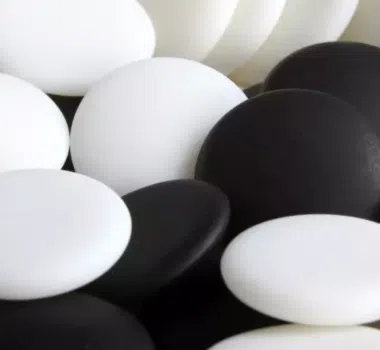 Gros plan sur les pierres de go en résine noires et blanches empilées