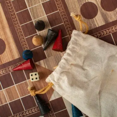 Close-up van Ludo-stukken en dobbelsteen op het inlegwerk-bord