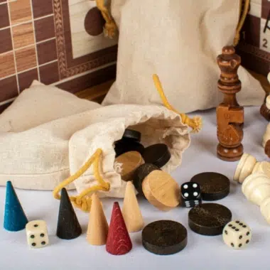 Backgammonschijven, dobbelstenen en schaakfiguren uitgestald voor de zakjes